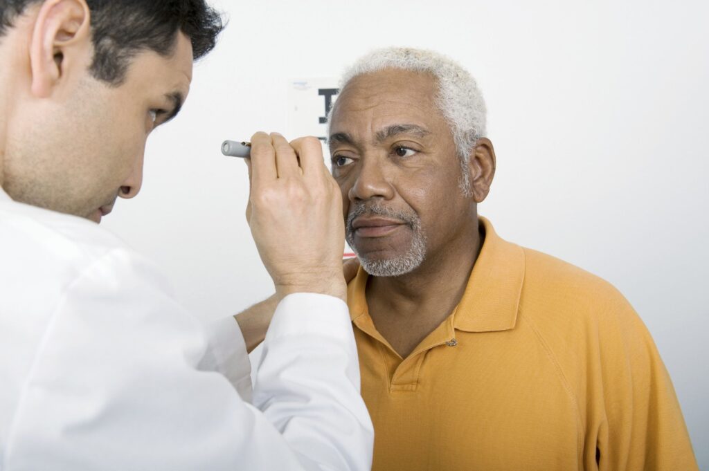 A Doctor Checking Eyes Of Senior Citizen
